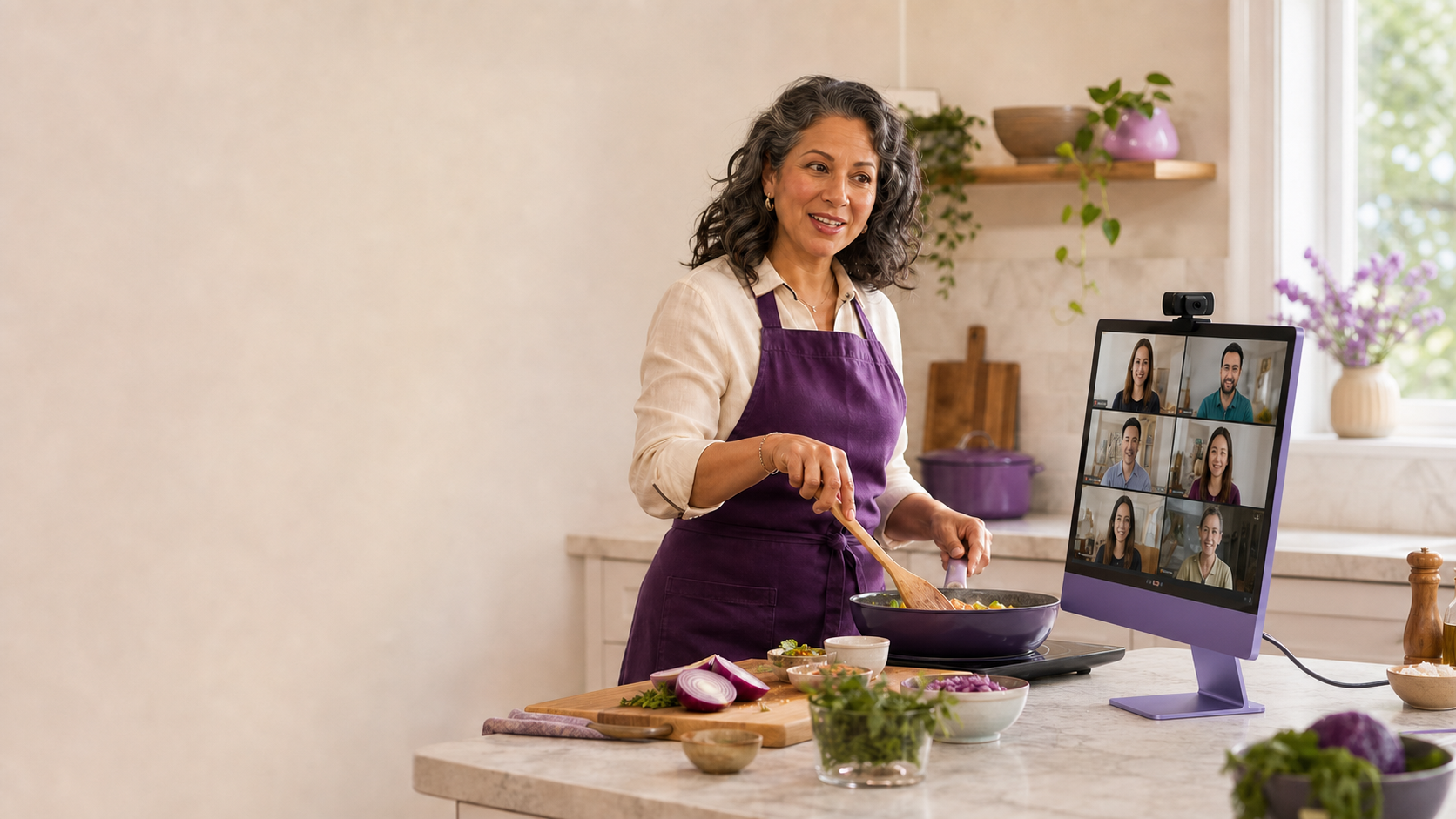 A cook presenting beside a purple iMac and connected USB webcam.